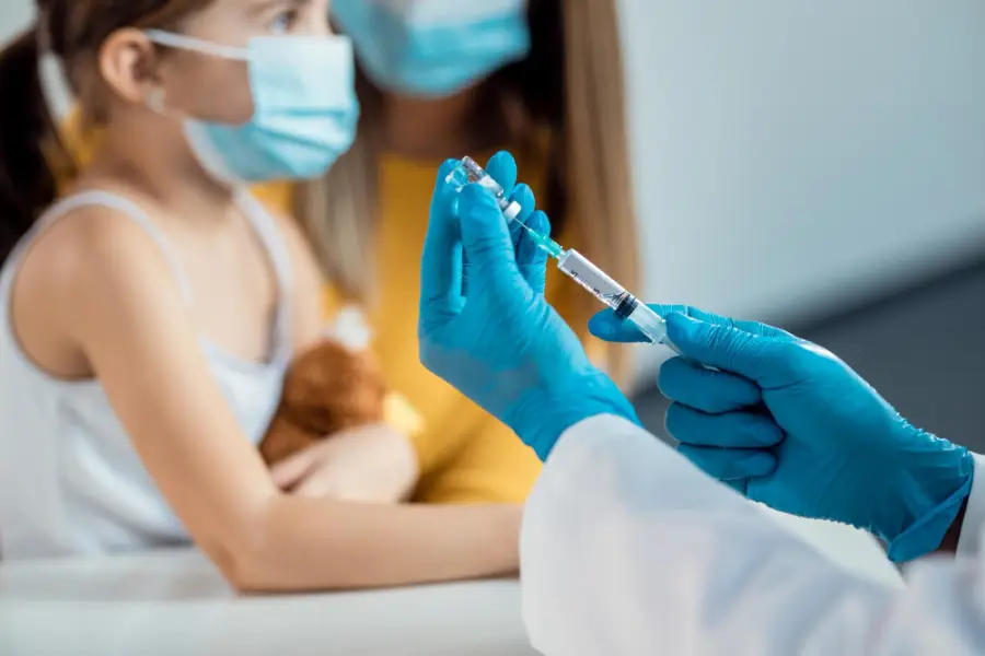Closeup of doctor preparing a syringe for child's vaccination